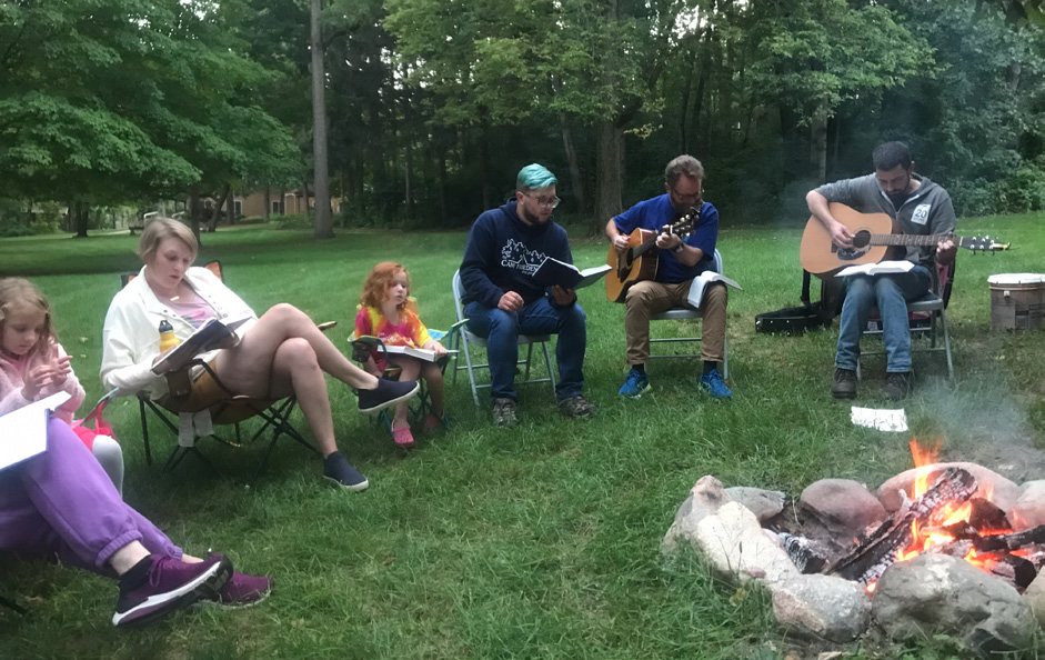 Grand Rapids Mennonite Fellowship worshiping outdoors around a campfire