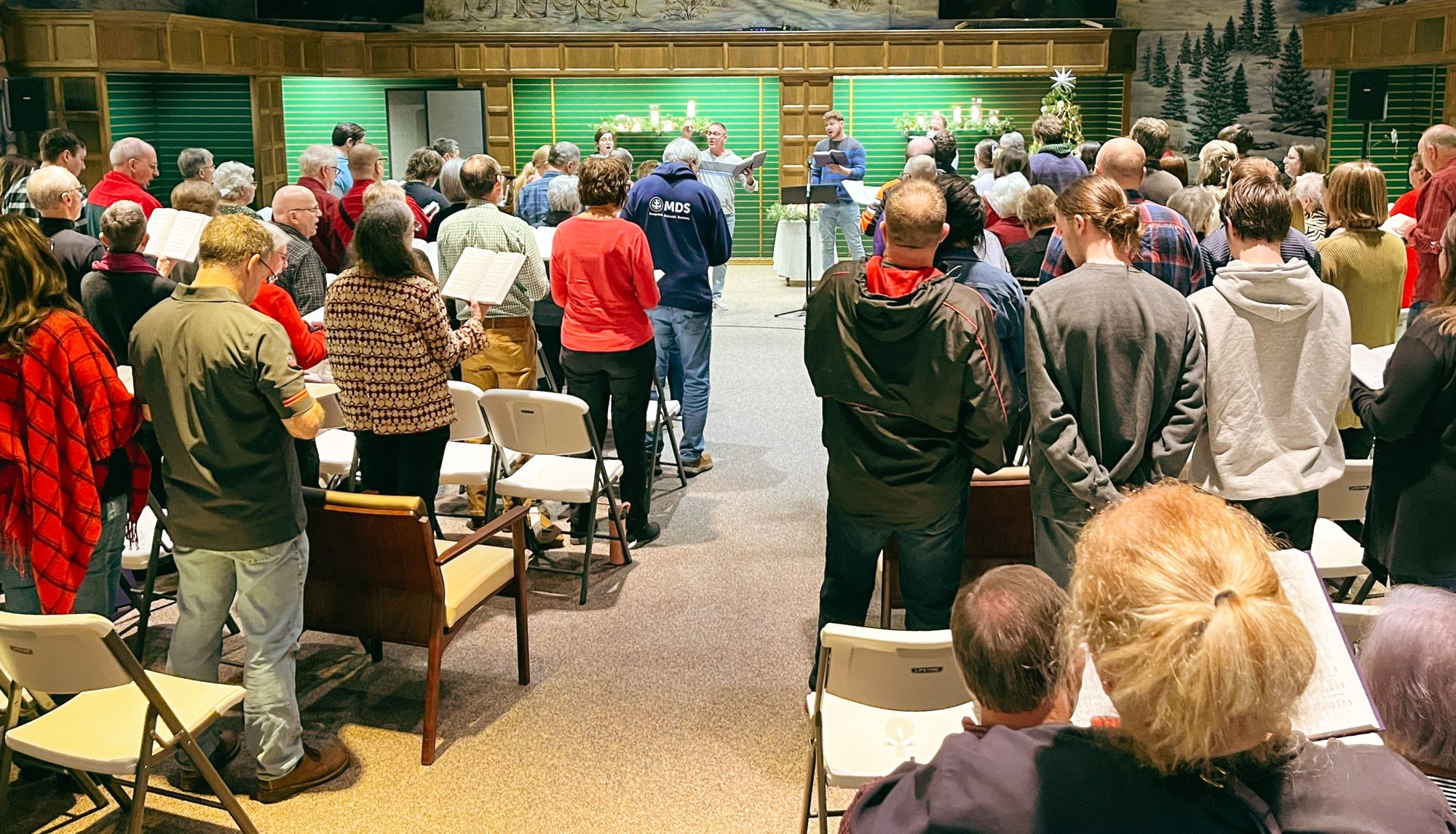 A full room of worshipers singing at PEACE Mennonite Fellowship